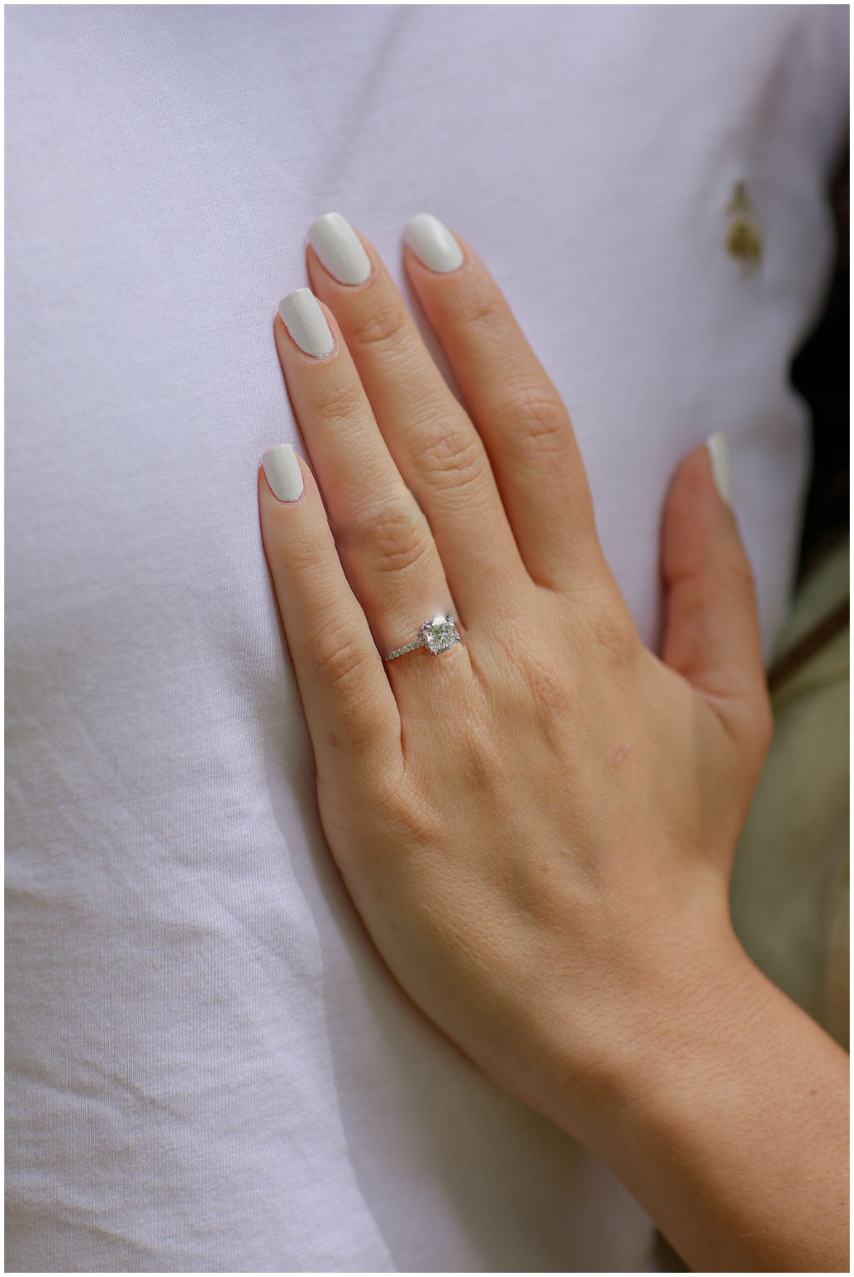 Details of a woman's hand resting on her fiance's chest with a diamond ring on it dc engagement photographer