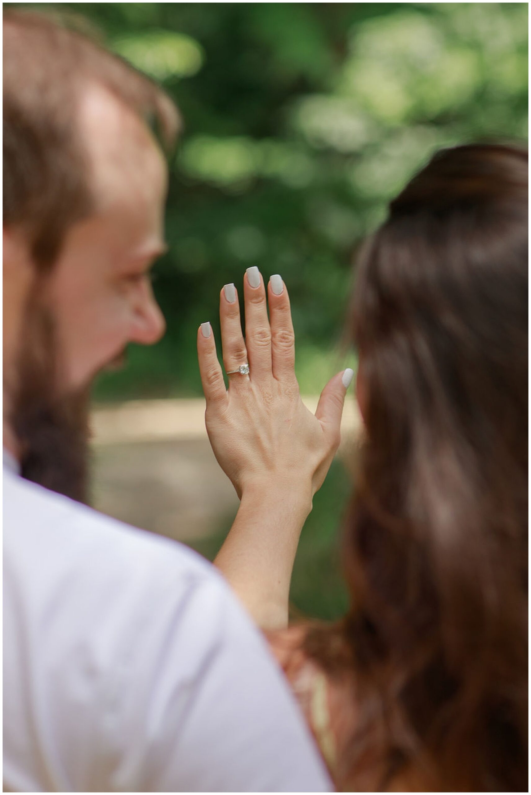 Details of a newly engaged couple looking at the ring
