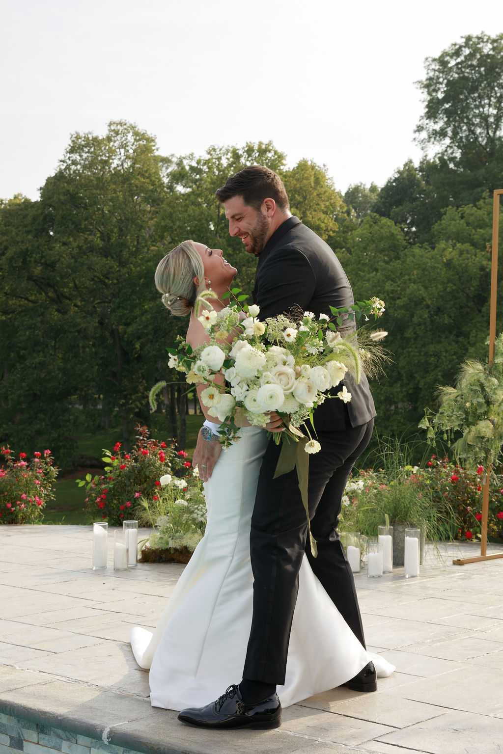 Newlyweds dance by a pool in a rose garden washington dc wedding florist
