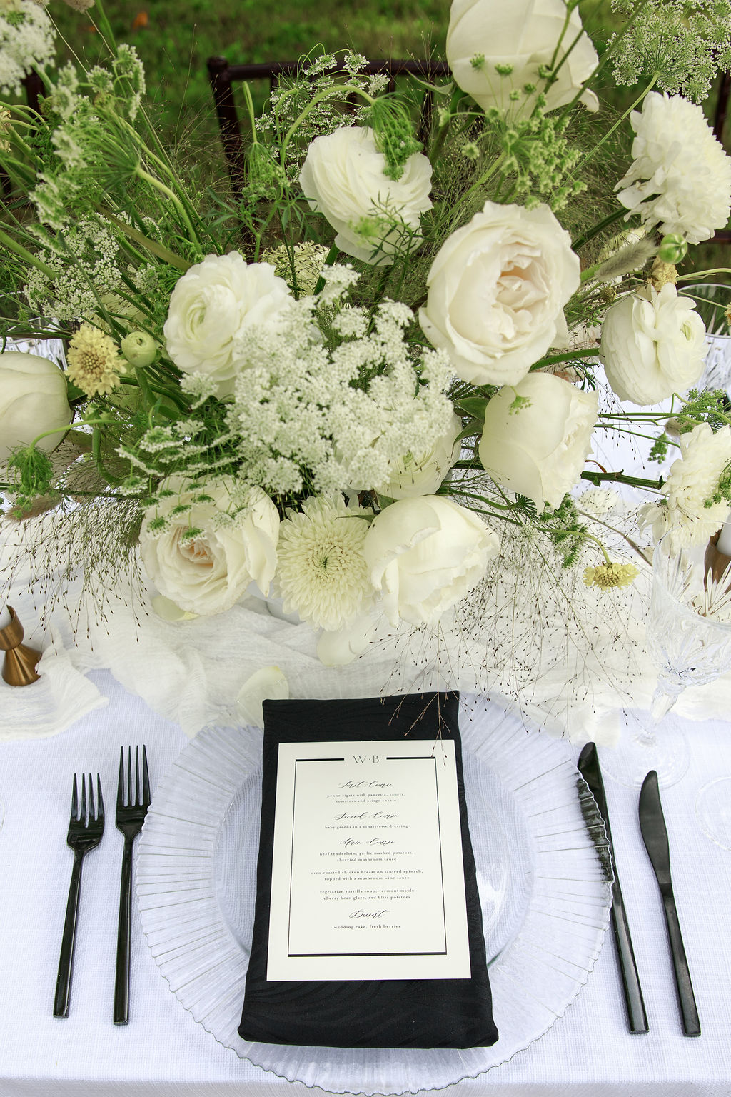 Details of a wedding reception table setting with white centerpiece