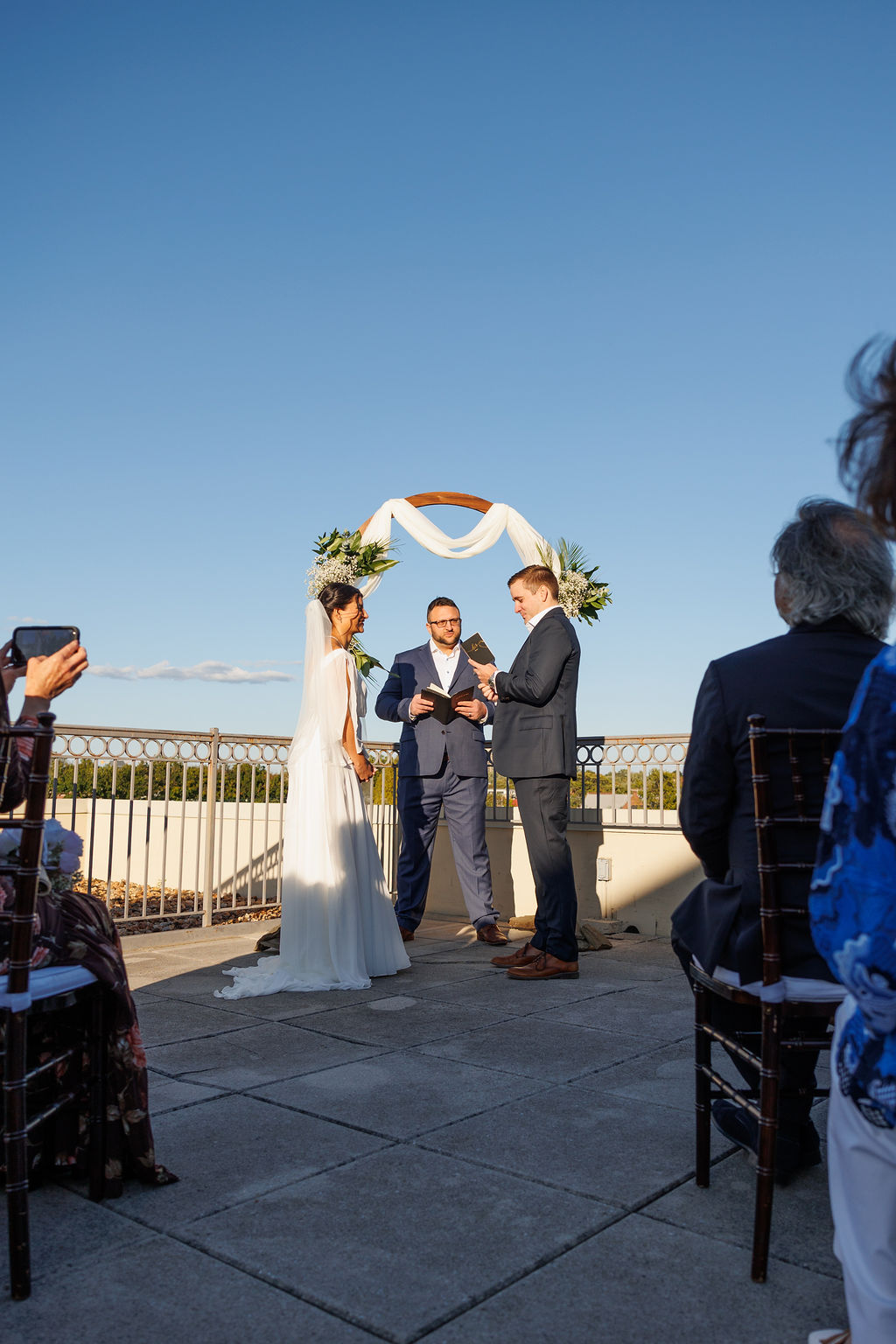 A groom stands at the altar reading his vows from a book to his bride during their lorien hotel wedding