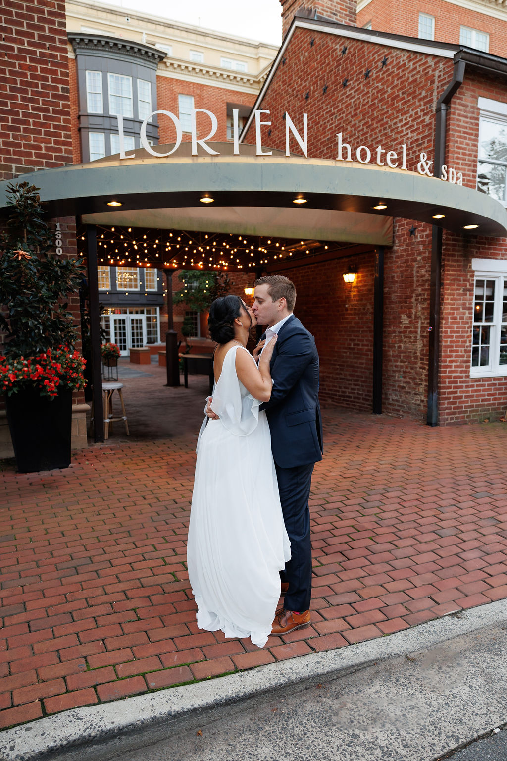 Newlyweds kiss under the front facade at their lorien hotel wedding