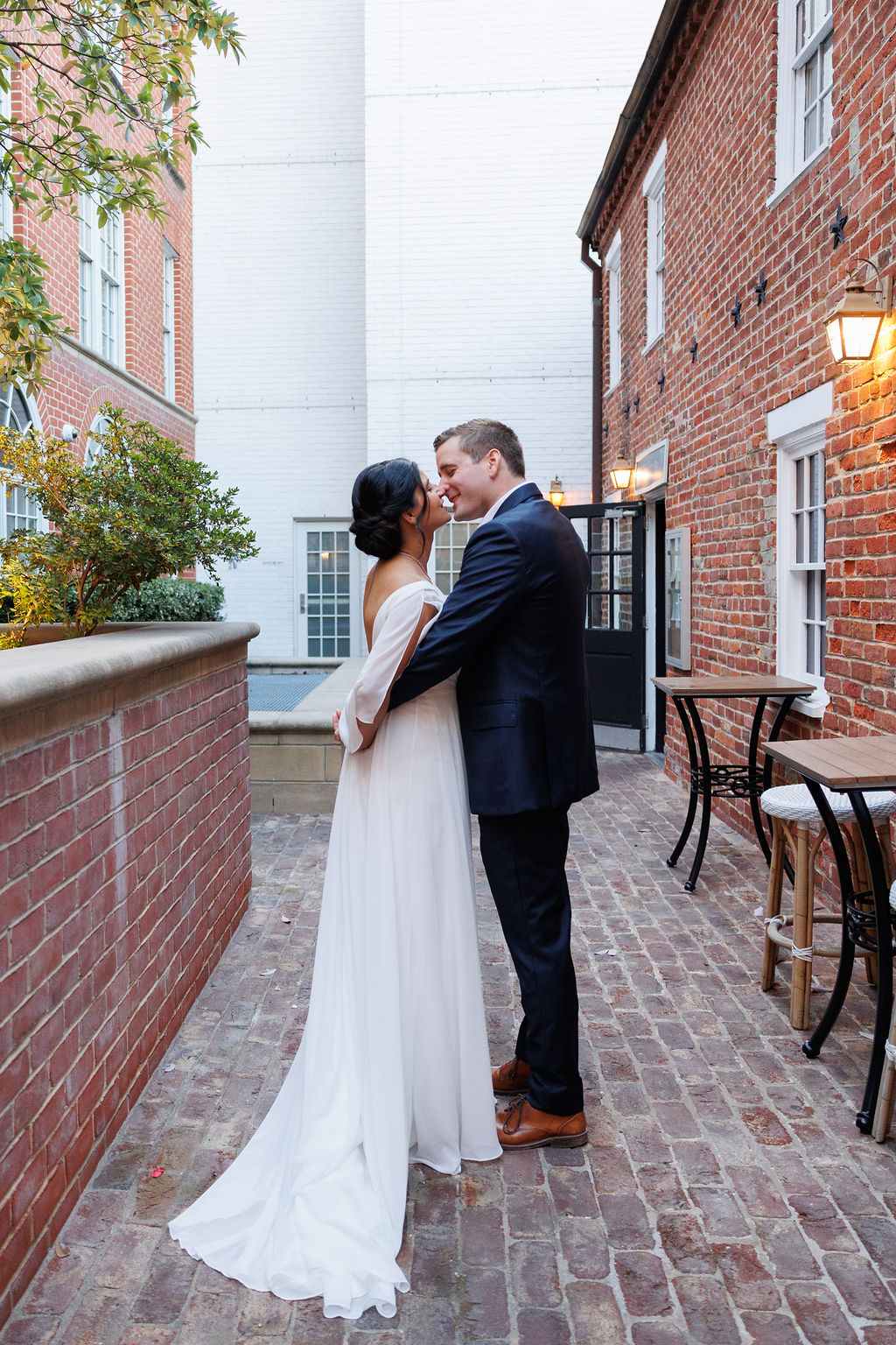 Newlyweds share a quiet kiss in an alley behind the lorien hotel wedding venue