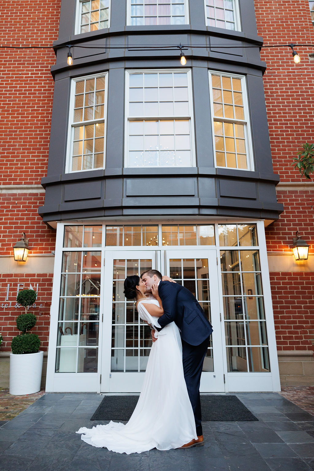Newlyweds kiss at the front entrance to the lorien hotel wedding venue