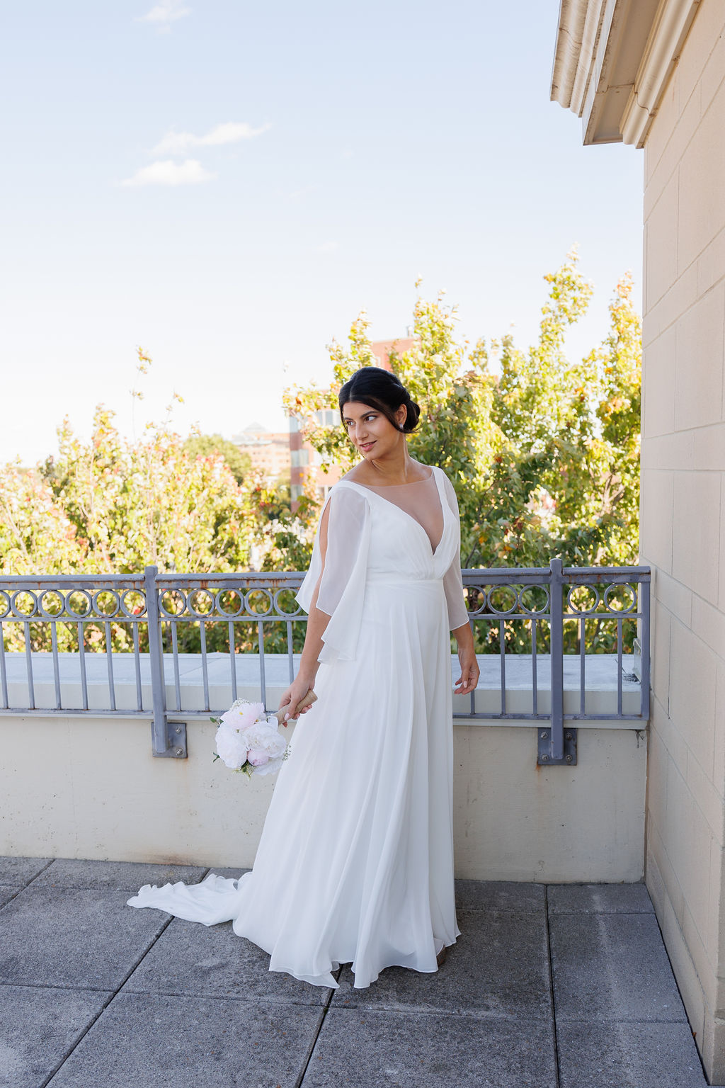 A bride gazes over her shoulder while standing on a rooftop at her lorien hotel wedding