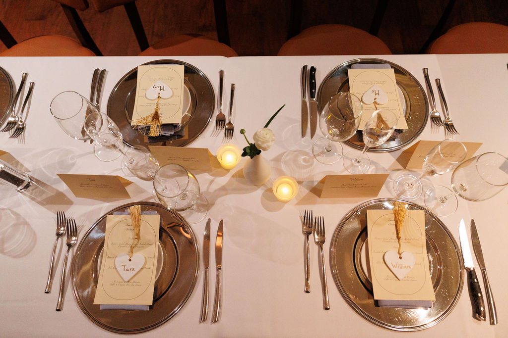 Details of a wedding reception table set with gold silverware and candles at a lorien hotel wedding