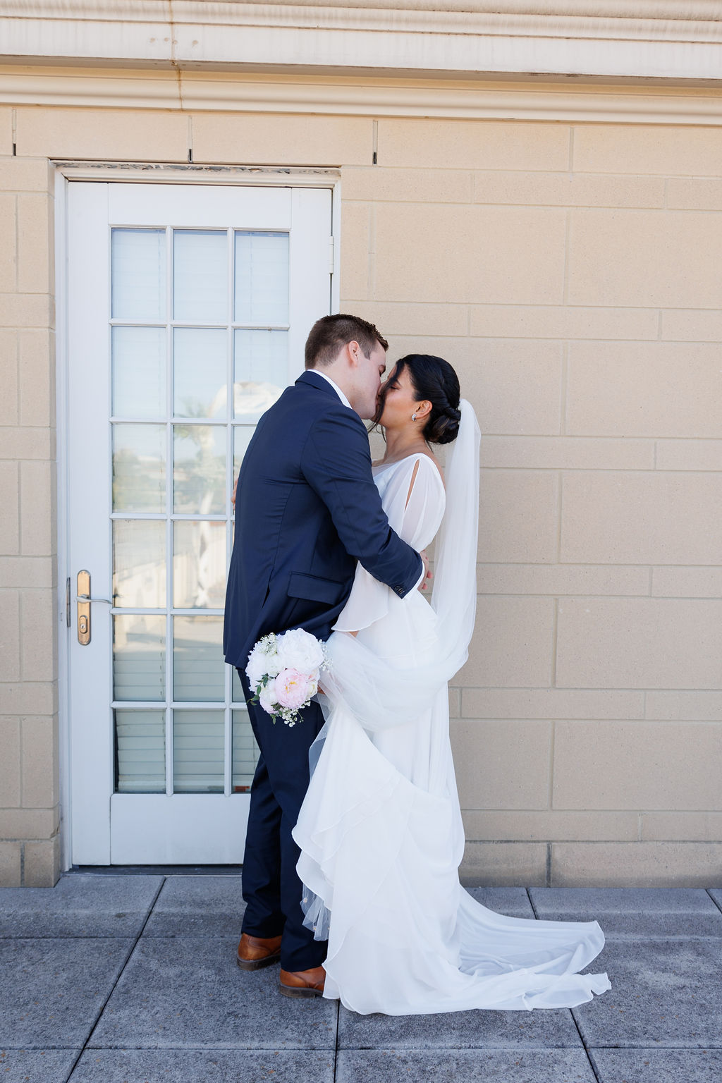 Newlyweds kiss in a back alley