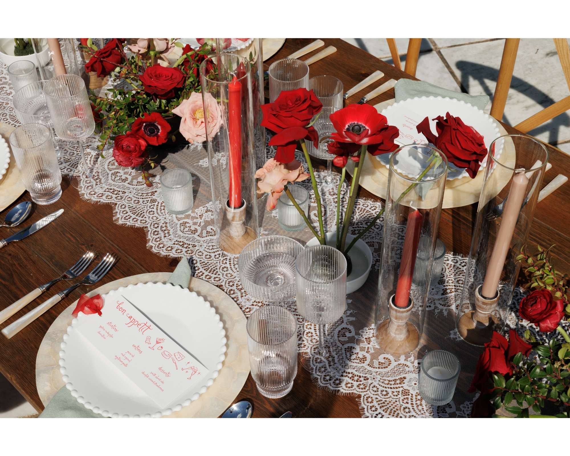 The dinner table set up with red florals and custom letterpress menus.