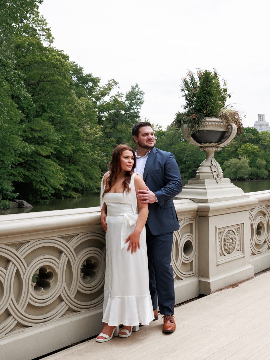 Couple poses for their engagement photos on the bridge in Central Park