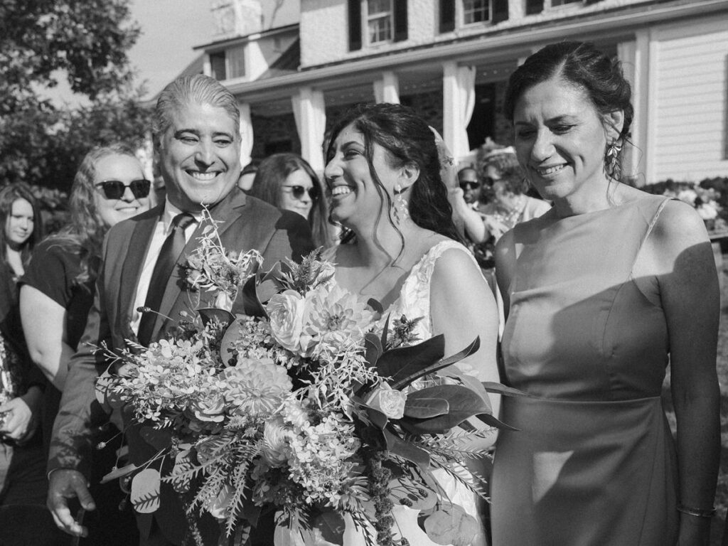 Black and white photograph of bride walking down the aisle to her groom