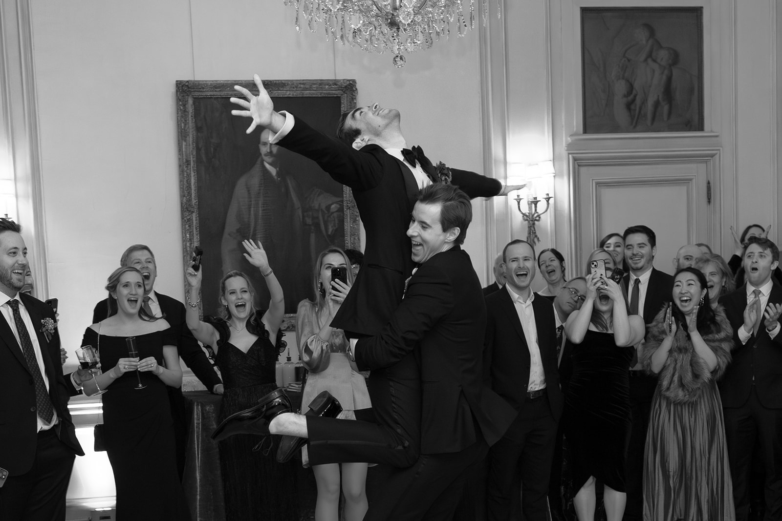Two grooms take their first dance and do a fun lift during their LGBTQ wedding held at Meridian House. 